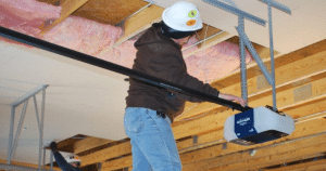 Worker installs garage door opener track.